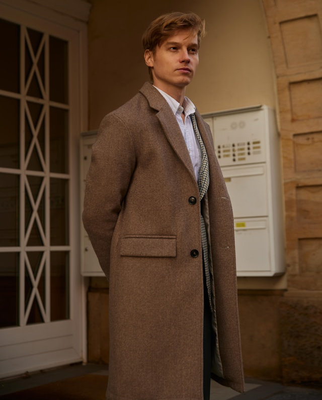 A man in a brown overcoat